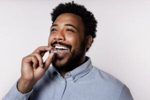 Man from Bridgewater placing Candid teeth aligners into his mouth