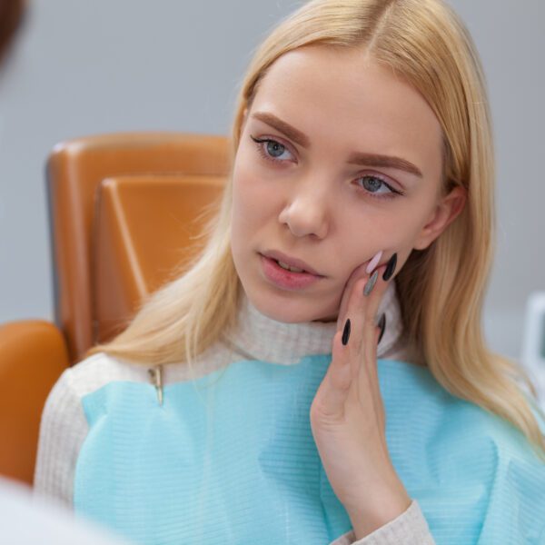 Woman with severe tooth pain in need of emergency dental care