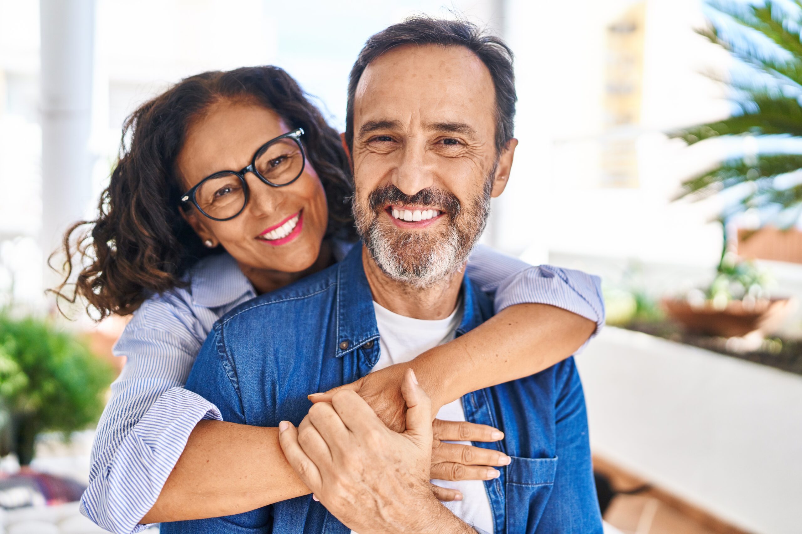 mature couple with their arms around each other showing off their flawless smiles, dental veneers