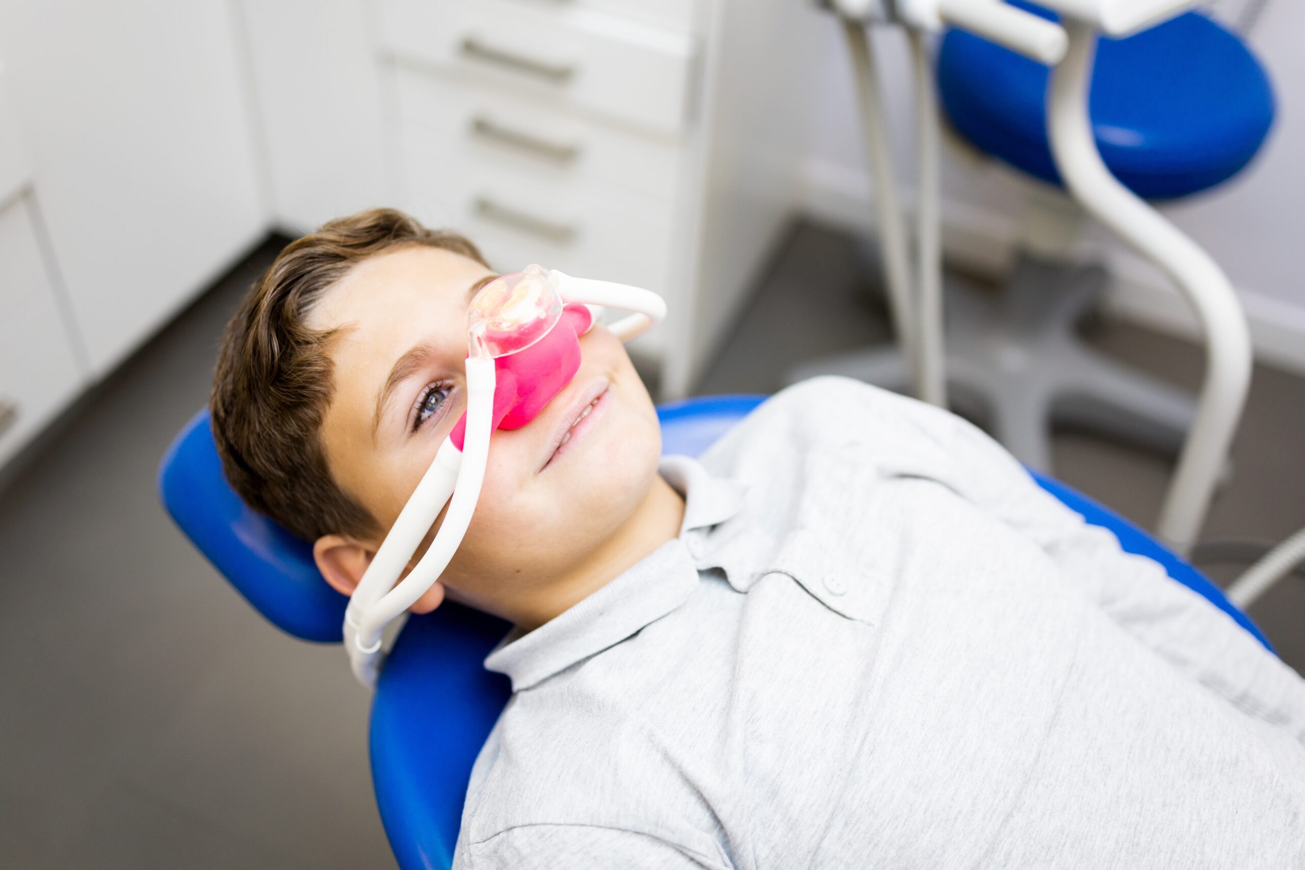 young boy relaxed in a dental chair, laughing gas sedation