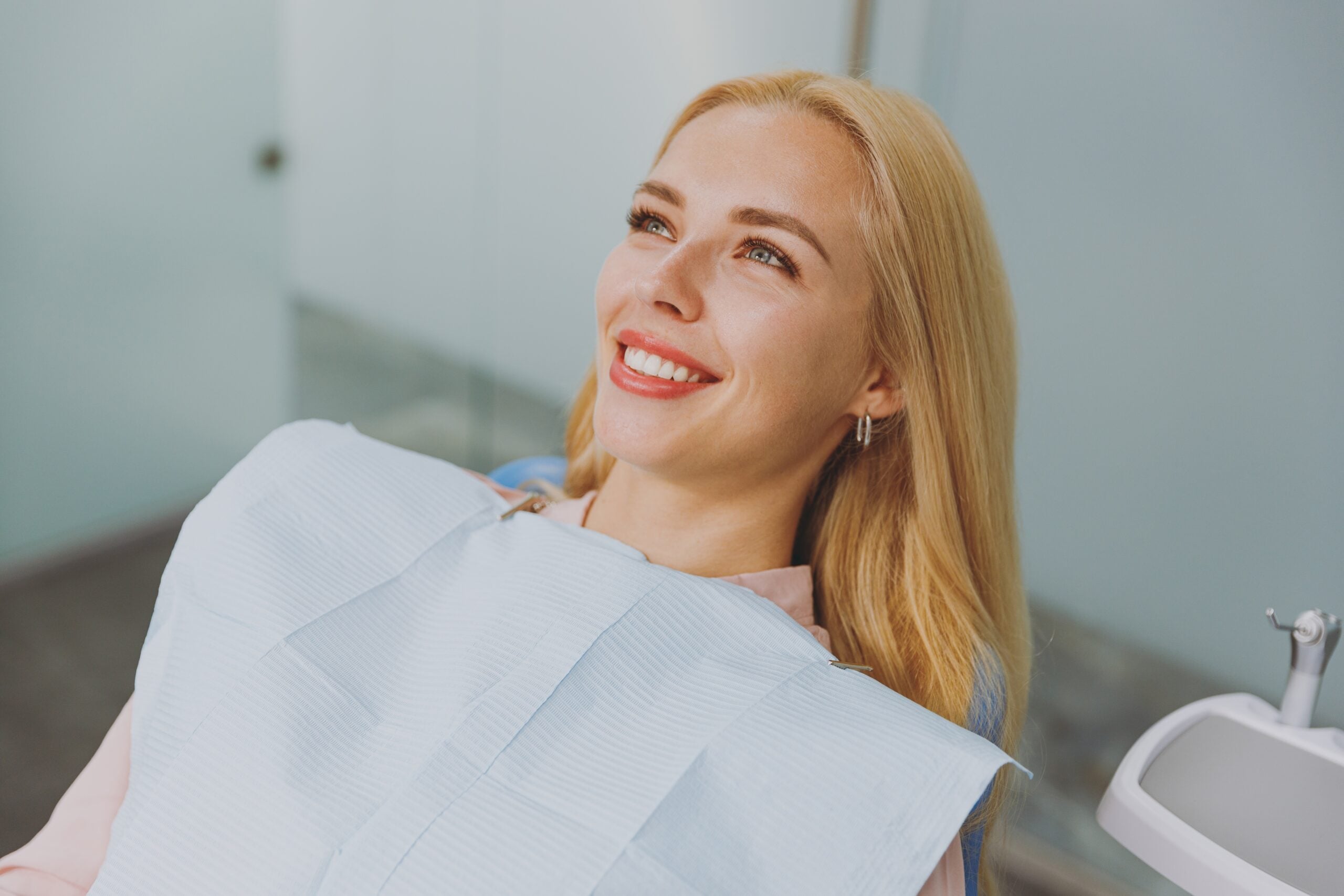 Happy, smiling, calm young woman sitting in a dental chair