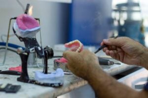 dentist preparing a dental restoration, dentures