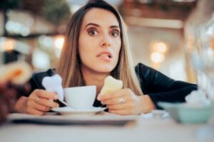 worried woman having coffee in a cafe, yellowing teeth
