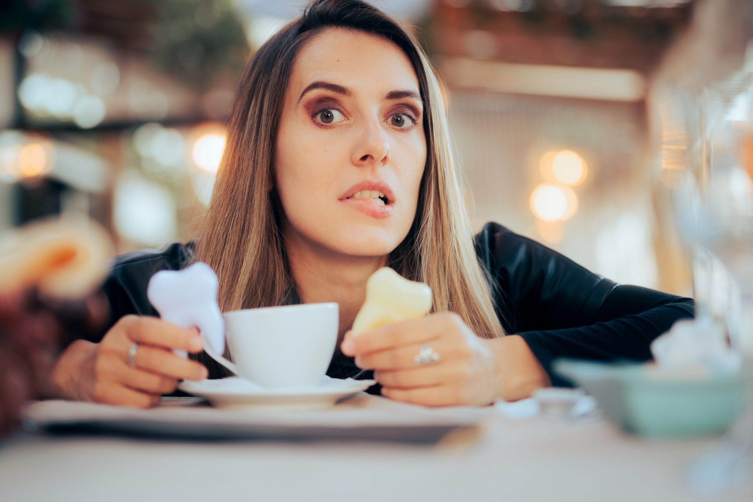 worried woman having coffee in a cafe, yellowing teeth